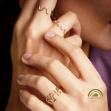 Close-up of hands wearing stackable gold rings part of the Odyssey Collection.