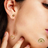 Close-up of a person wearing a gold geometric earring.