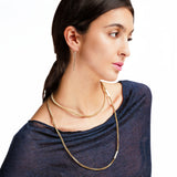 Woman wearing a silver necklace and earrings on a white background