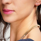 Close-up of a woman wearing paper chain earrings and necklace.