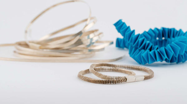Silver ribbons with a blue paper prototype and the silver Paperchain necklace at the centre