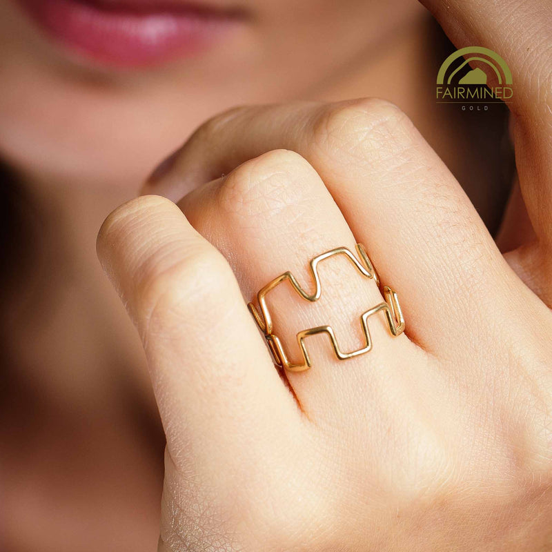 Two stackable rings on a finger with 'Fairmined' logo in the corner