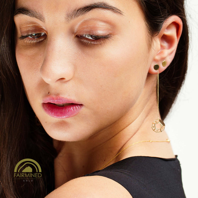 Close-up of a woman wearing gold earrings and a necklace with a white background