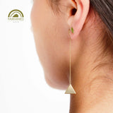Gold pyramidal earring worn, part of the on a roll collection.